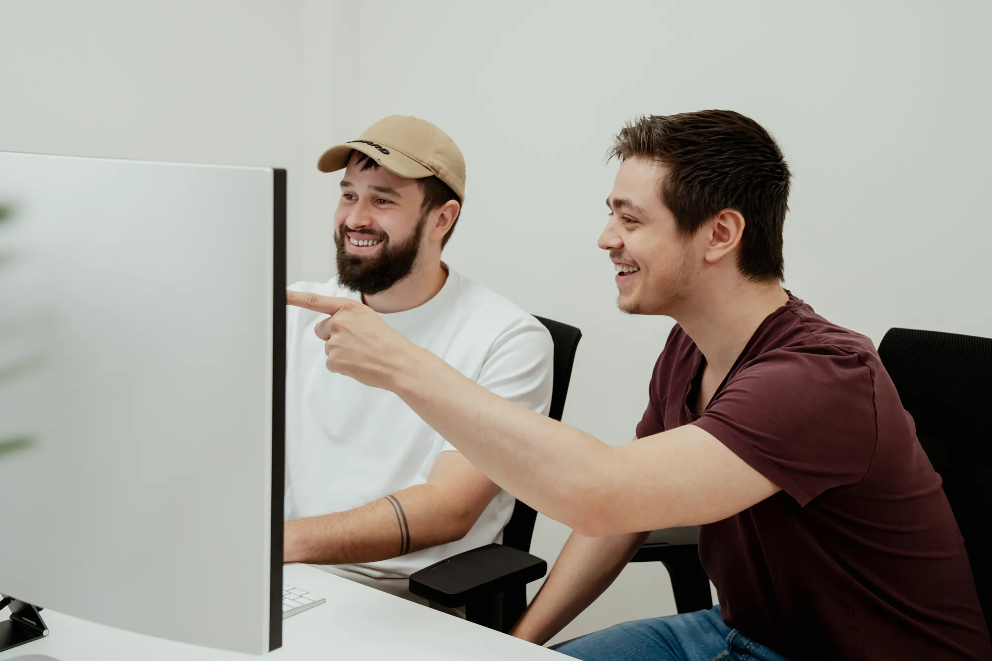 Twee collega's overleggen lachend aan een bureau